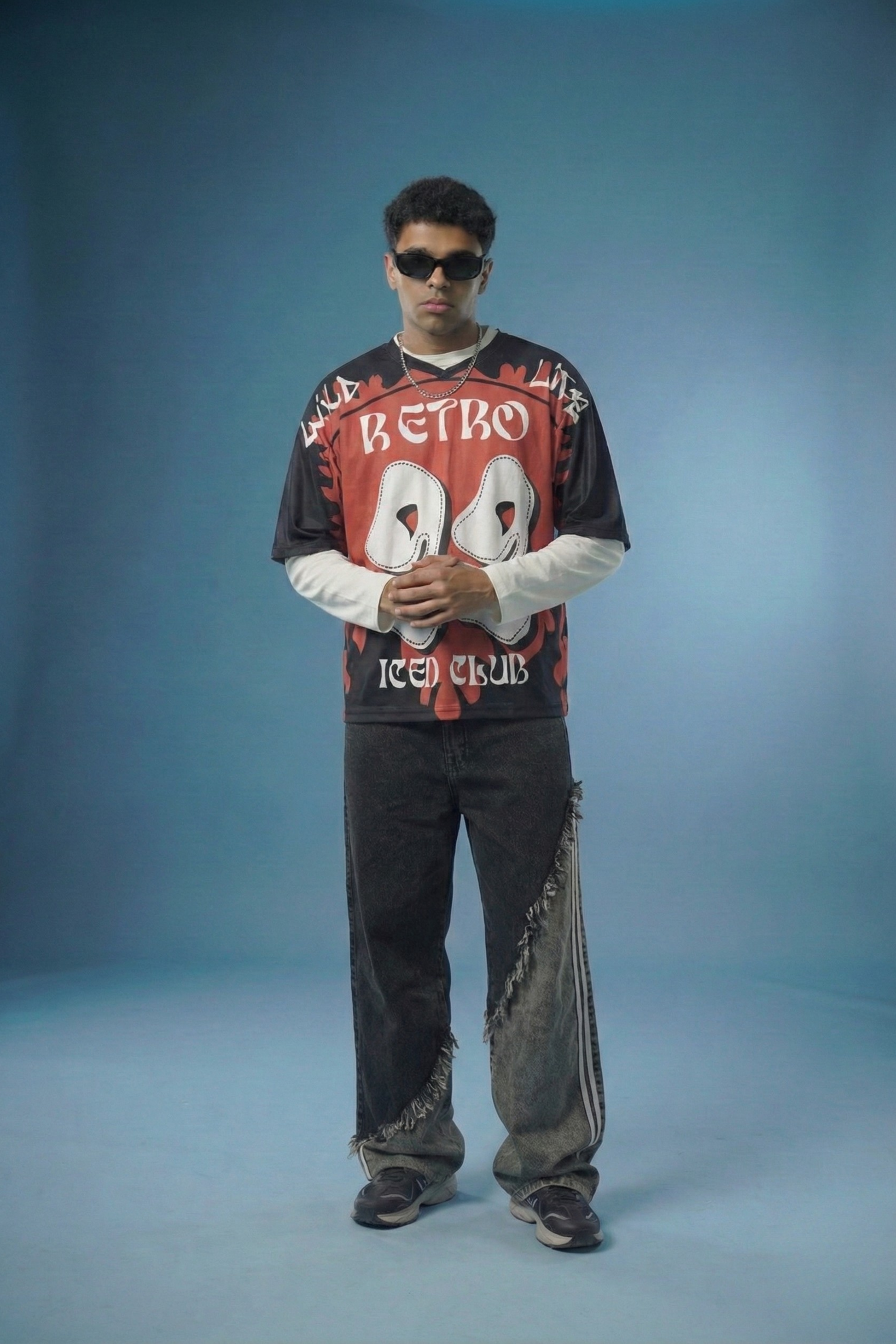 Person wearing a retro-themed sweatshirt and jeans on a blue background