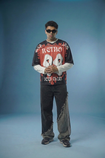 Person wearing a retro-themed sweatshirt and jeans on a blue background